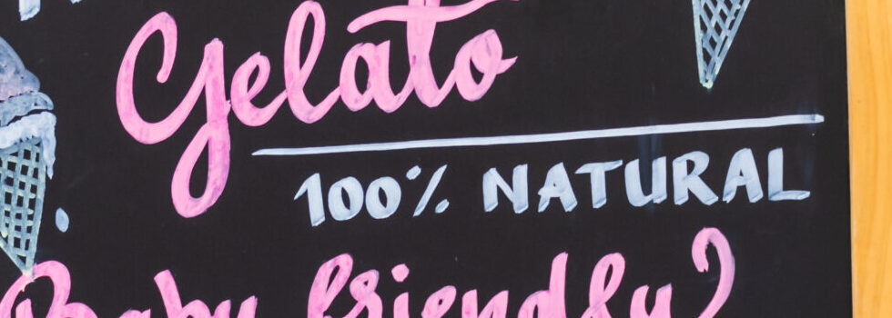 Gluten free, lactose free, gluten free ice cream sign. Advertisement on chalk board during food festival. Vintage retro italian car behind the sign. intolerance free dessert shop directional ad text