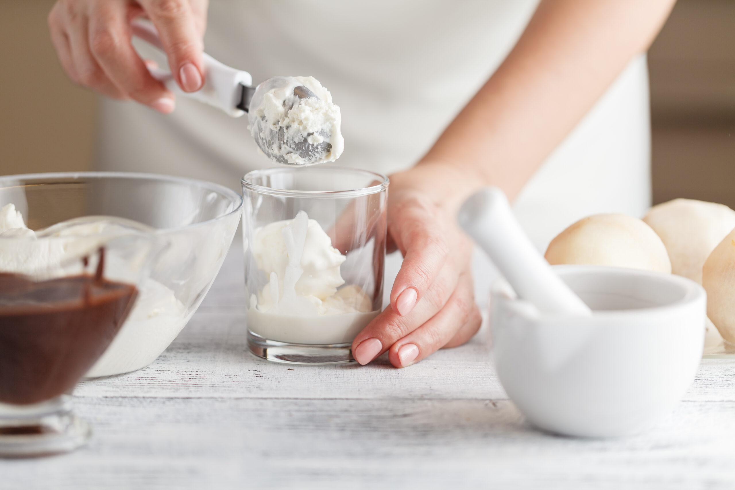 Pouring chocolate sauce onto ice cream