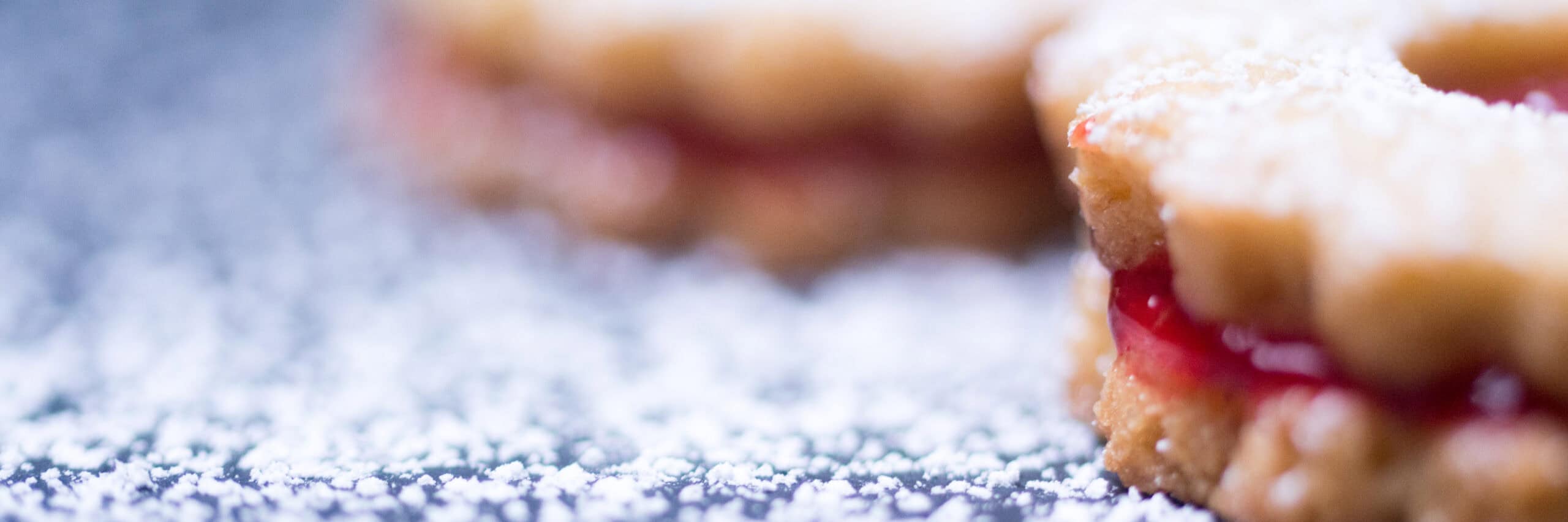 Jam-filled cookie dusted with powdered sugar representing artisan quality and clean-label