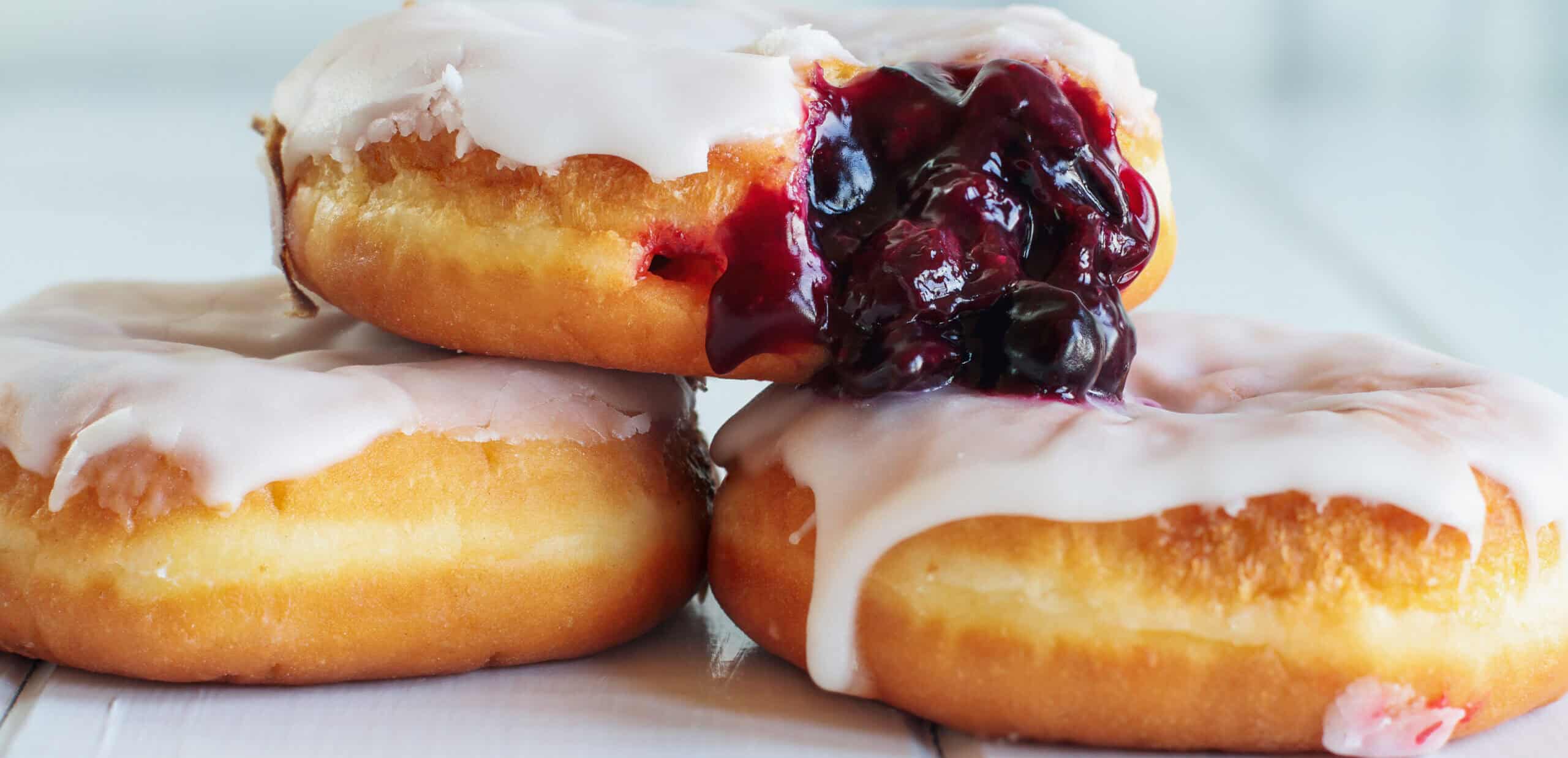 Glazed donuts with fruit jam filling showing portion-sized bakery trends for convenient on-the-go snacking