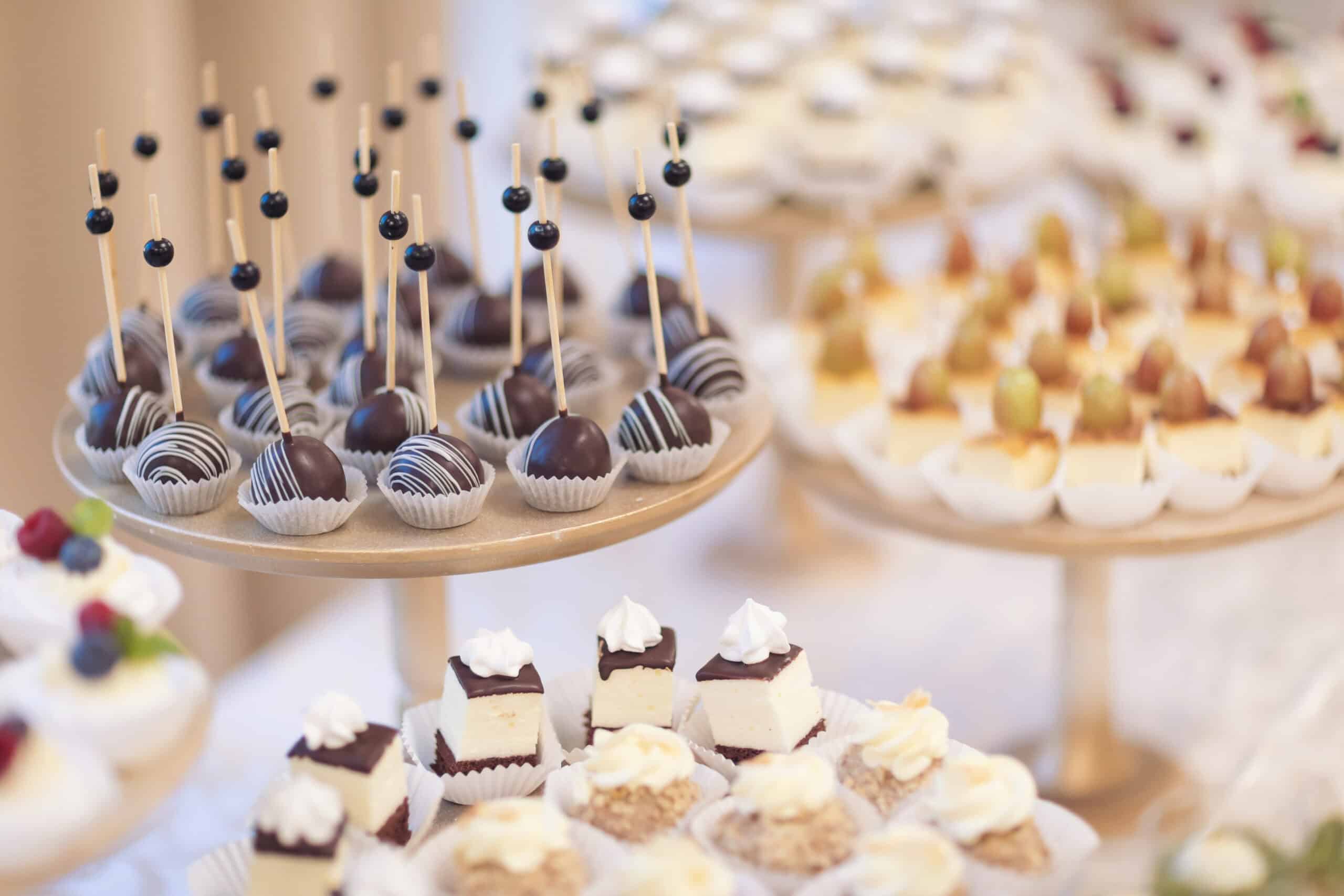Elegantly plated petit fours and chocolate truffles with berry garnish representing premium craft baked goods