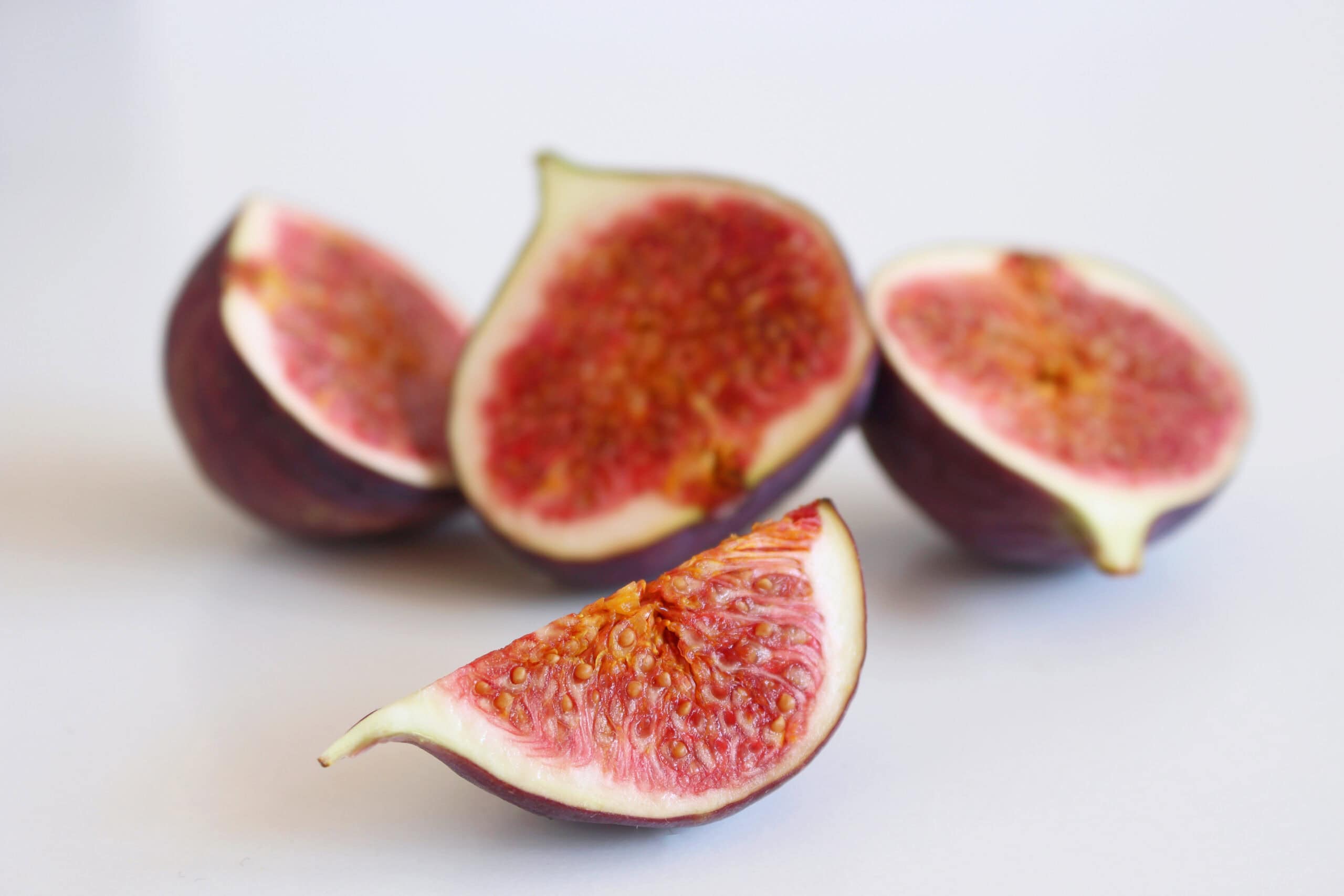 Halved and sliced fresh figs on a light background highlighting the Mediterranean fruit trend gaining popularity in bakery applications