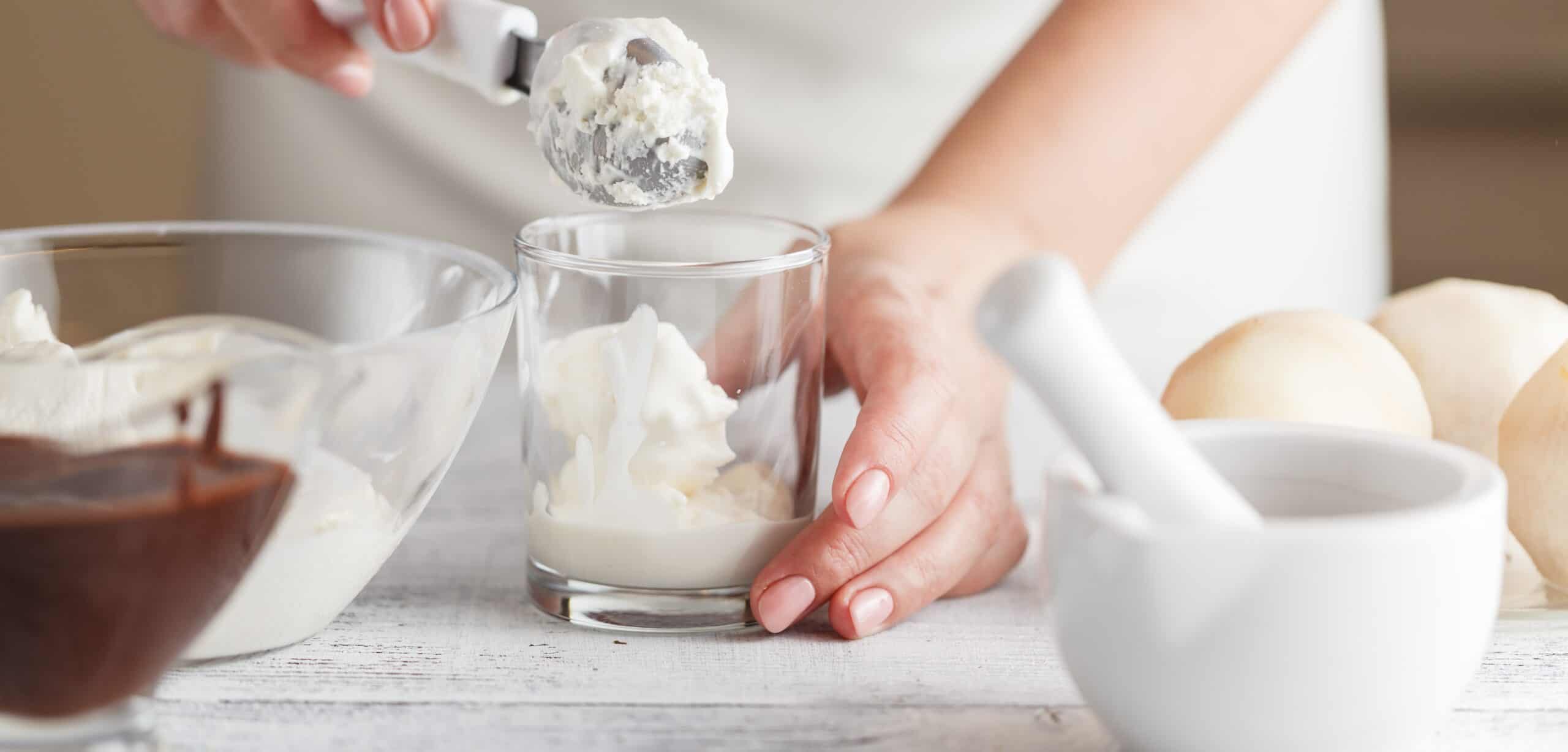 A food developer hand-scooping ice cream alongside chocolate, cream, and a mortar and pestle — the collaborative R&D behind functional ice cream formulation.