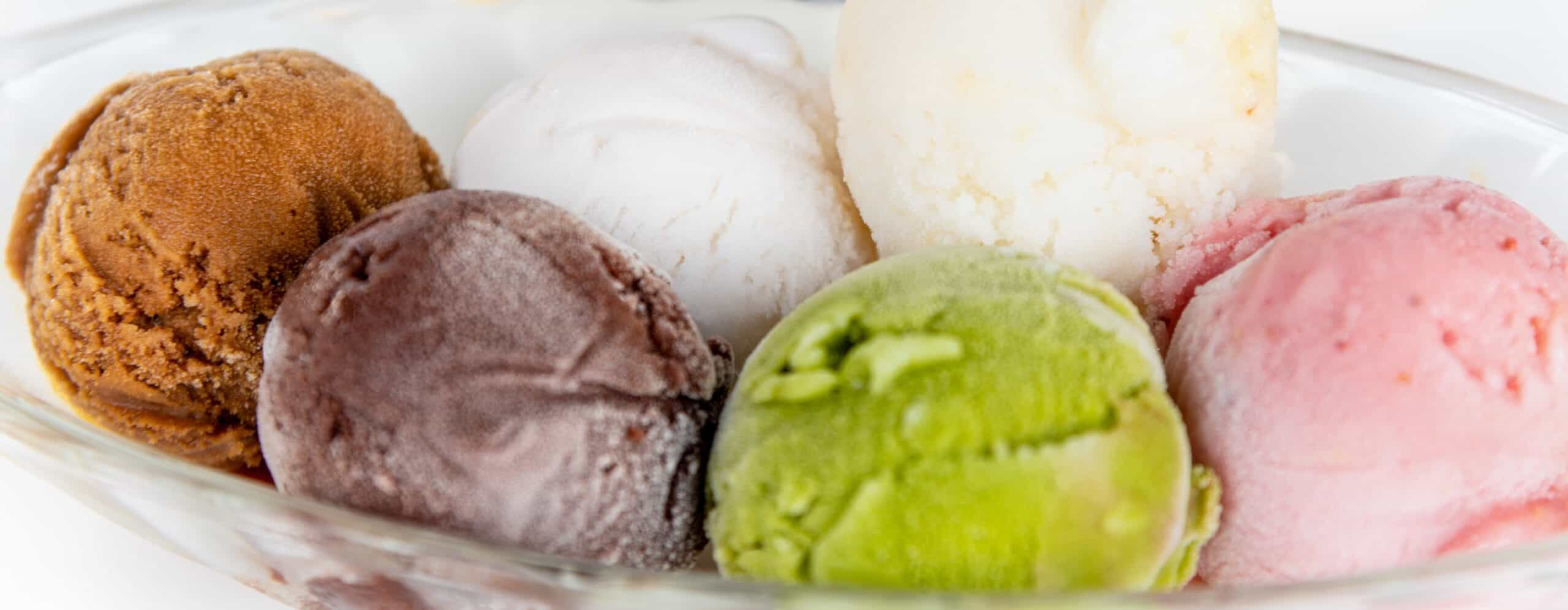 Six naturally colored ice cream scoops — caramel, chocolate, vanilla, matcha, strawberry — illustrating the natural color challenge in ice cream formulation.