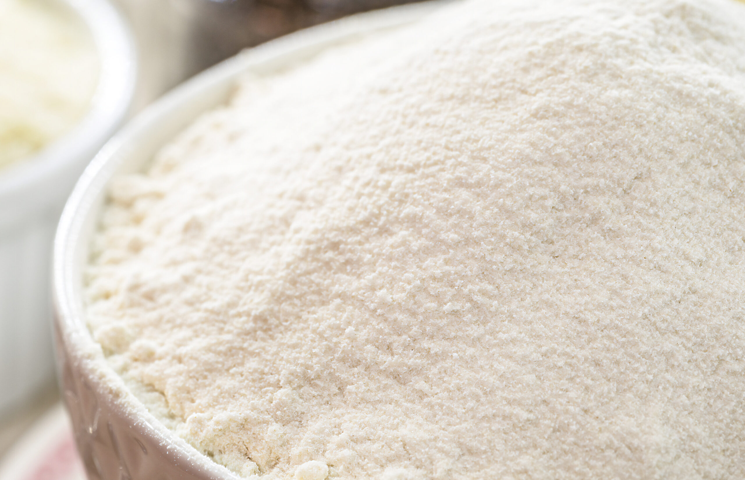 Bowl of soft white flour, representing the starches and stabilizers used to control texture and boil-out in bake-stable fruit fillings.