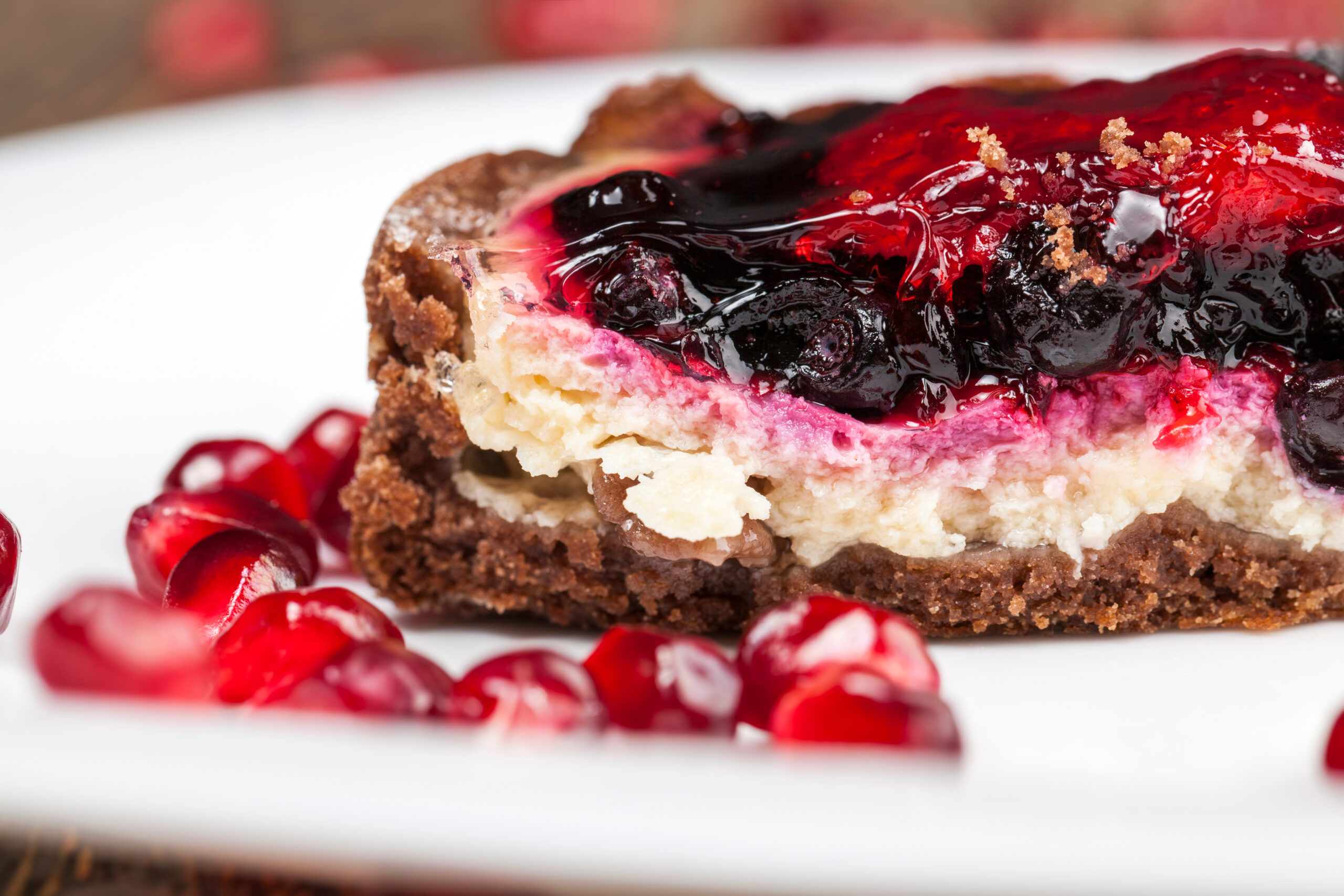 Cross-section of a layered berry bar showing the fruit filling between topping and pale base, illustrating moisture migration between components.