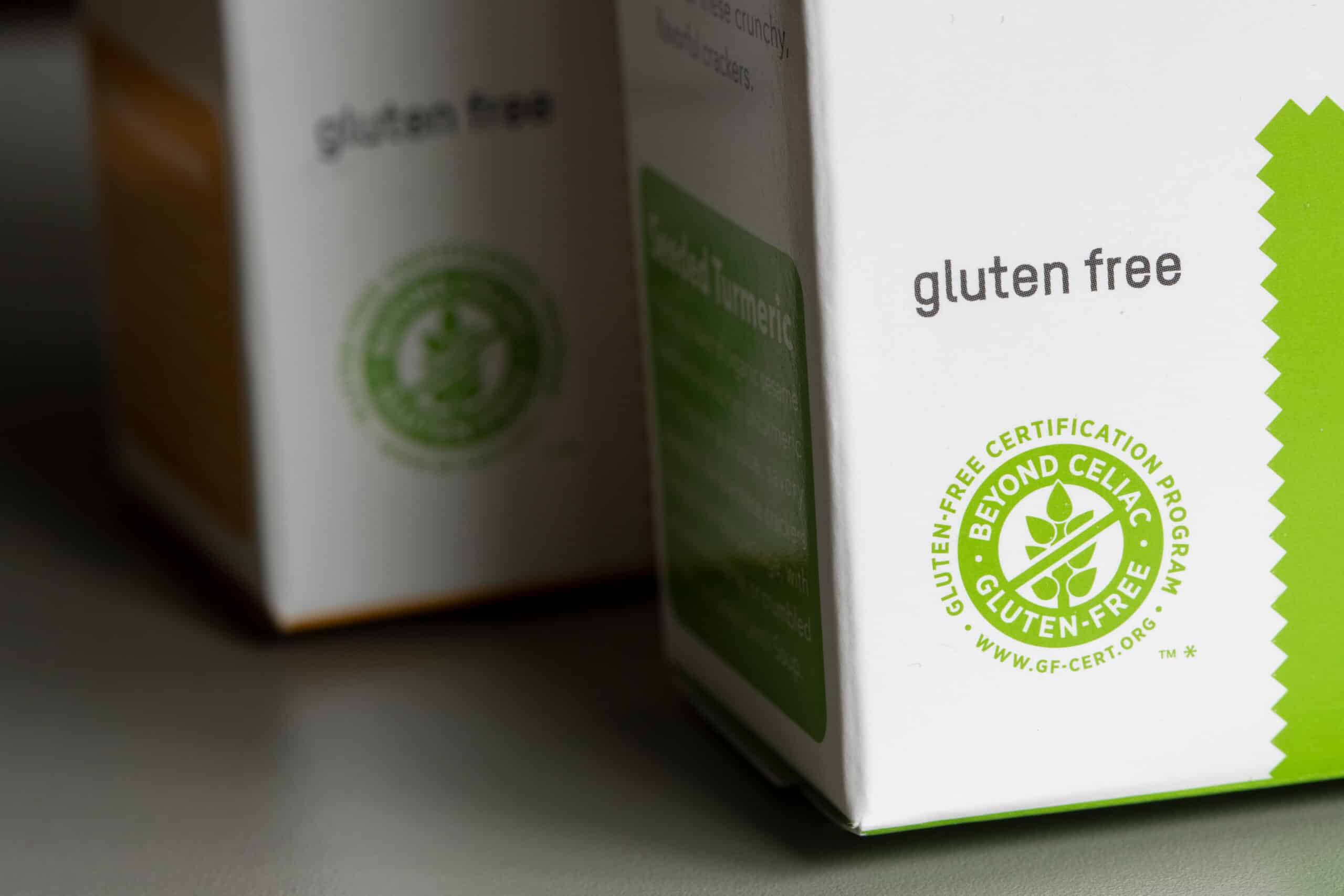 Close-up of a Beyond Celiac gluten-free certification seal on a white product box, illustrating the allergen labeling and certification developers rely on for food safety.