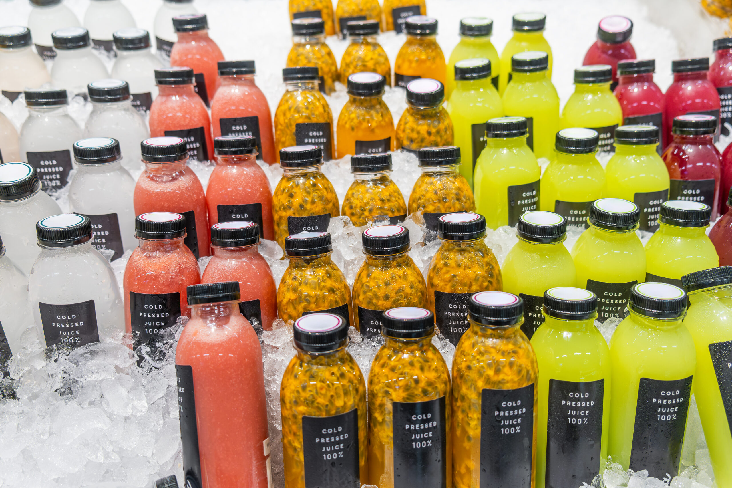 Cold pressed juice bottles on ice in a retail case, a leading food service beverage trend